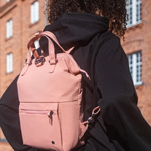 Load image into Gallery viewer, Woman travelling with the Pacsafe Citysafe CX Anti-Theft Mini Backpack color Rose made with ECONYL® regenerated nylon
