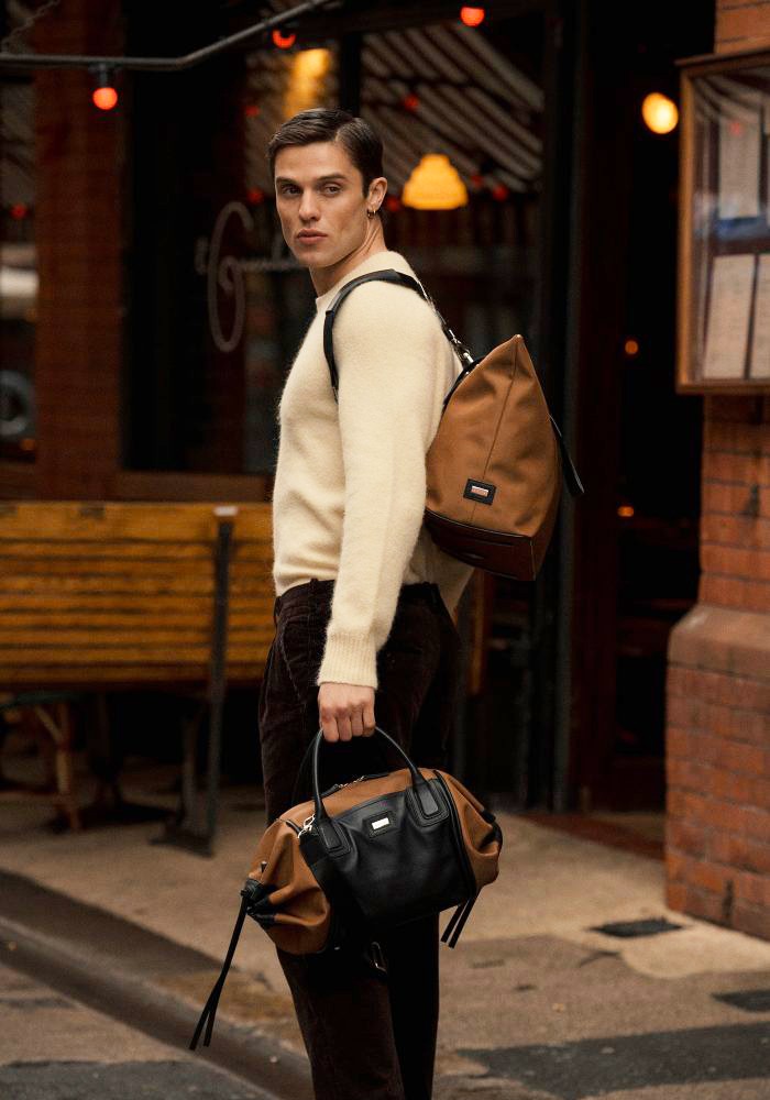 Man carrying The Gallery Duffel Bag aoife® color Brown and Black made with ECONYL® regenerated nylon