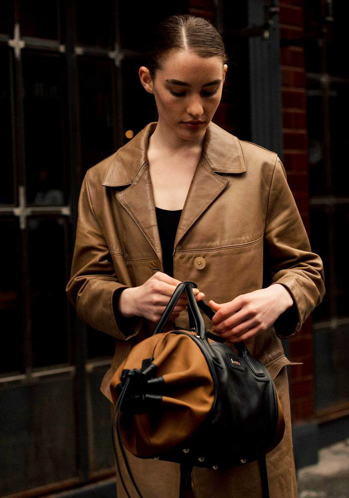 Woman carrying The Gallery Duffel Bag aoife® color Brown made with ECONYL® regenerated nylon