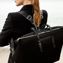 Load image into Gallery viewer, Woman carrying The Gallery Tote To Backpack aoife® color Black made with ECONYL® regenerated nylon
