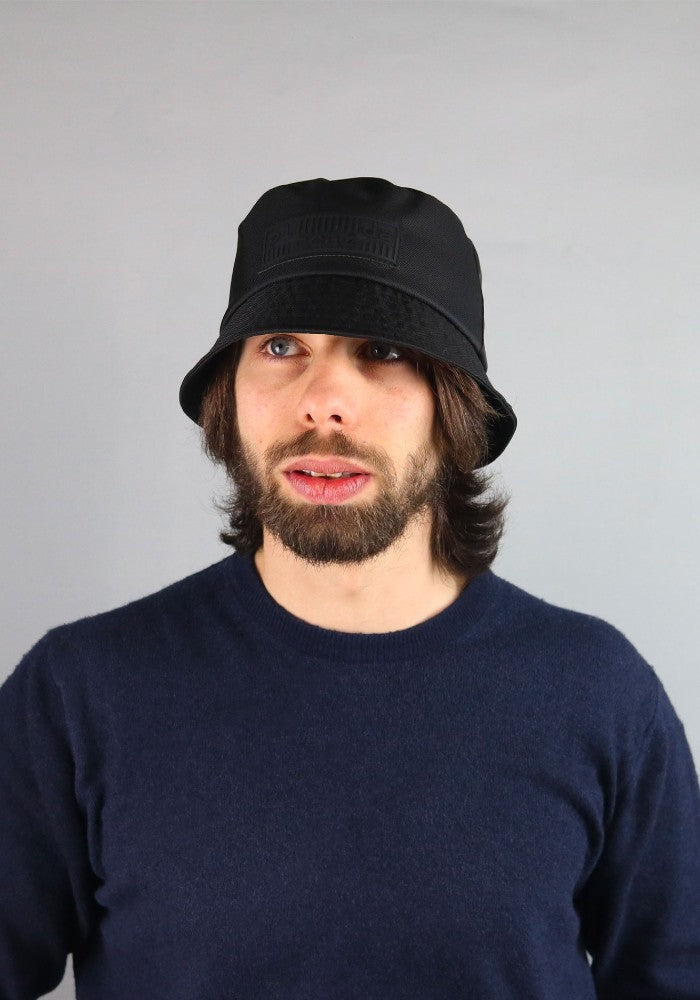 Man wearing Ecobucky, the waterproof bucket hat by Complit color Black made with ECONYL® regenerated nylon with style