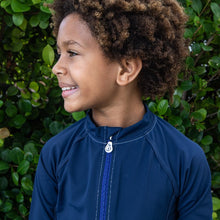 Load image into Gallery viewer, Kid wearing the NoNetz NoRash Guard for Kids color Navy made with ECONYL® regenerated nylon
