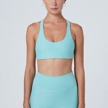 Load image into Gallery viewer, Front view of a woman wearing the Alva Sports Bra Arctic by Outfyt color Pale Blue made with ECONYL® regenerated nylon
