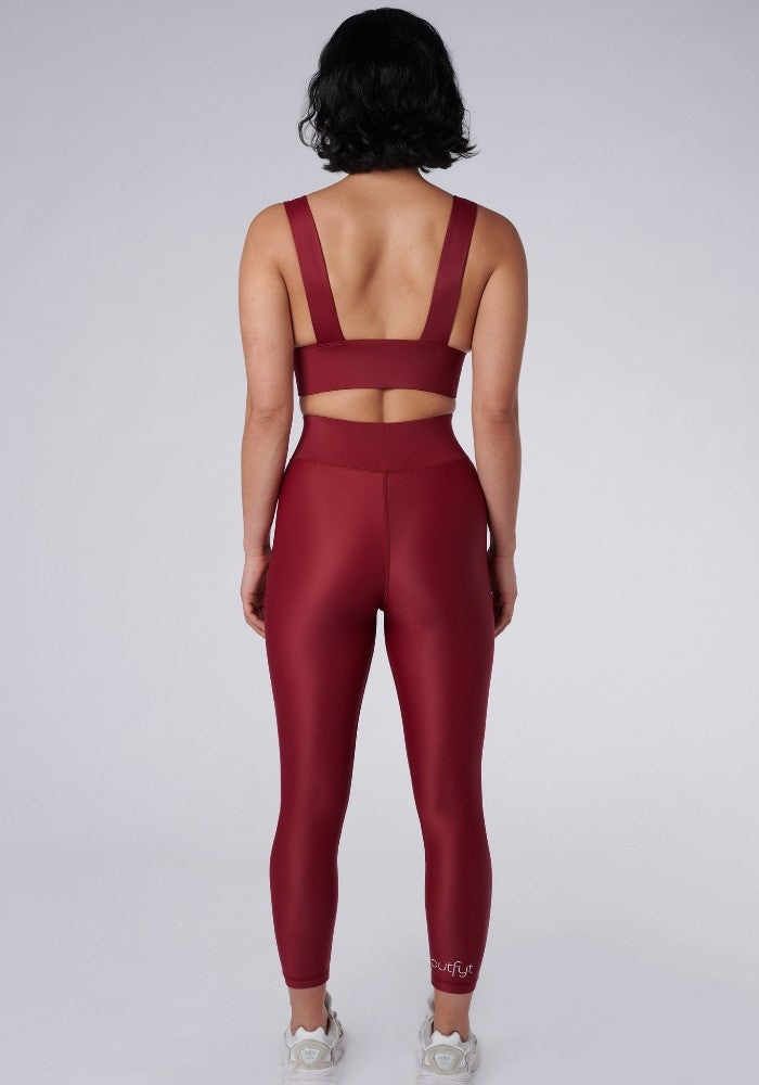 Back view of a woman wearing the Cora Leggings Wine by Outfyt color Red made with ECONYL® regenerated nylon