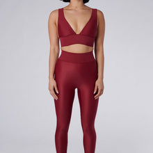 Load image into Gallery viewer, Front view of a woman wearing the Cora Leggings Wine by Outfyt color Red made with ECONYL® regenerated nylon
