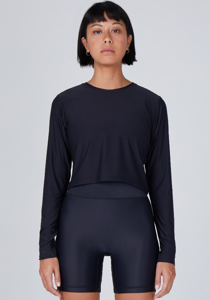 Front view of a woman wearing the Elin Long Sleeve Crop by Outfyt color Black made with ECONYL® regenerated nylon