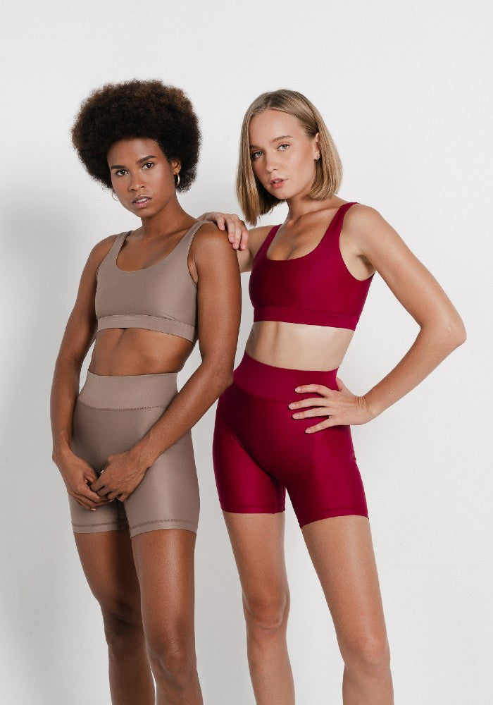 Women wearing the Mera Sports Bra Wine by Outfyt color Red made with ECONYL® regenerated nylon
