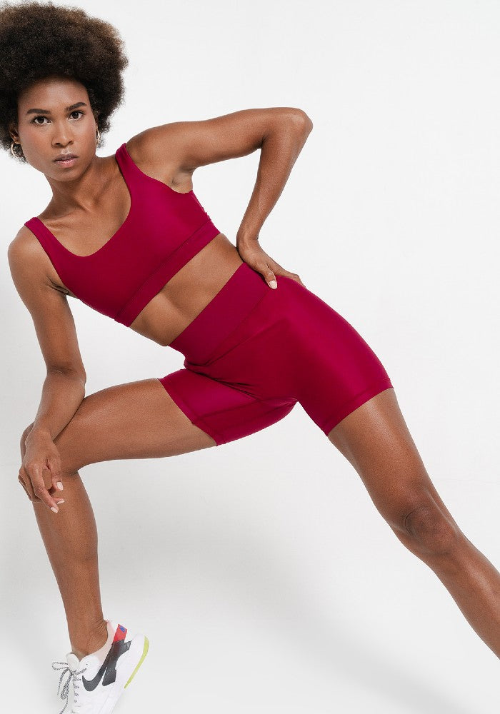 Woman wearing the Mera Sports Bra Wine by Outfyt color Red made with ECONYL® regenerated nylon