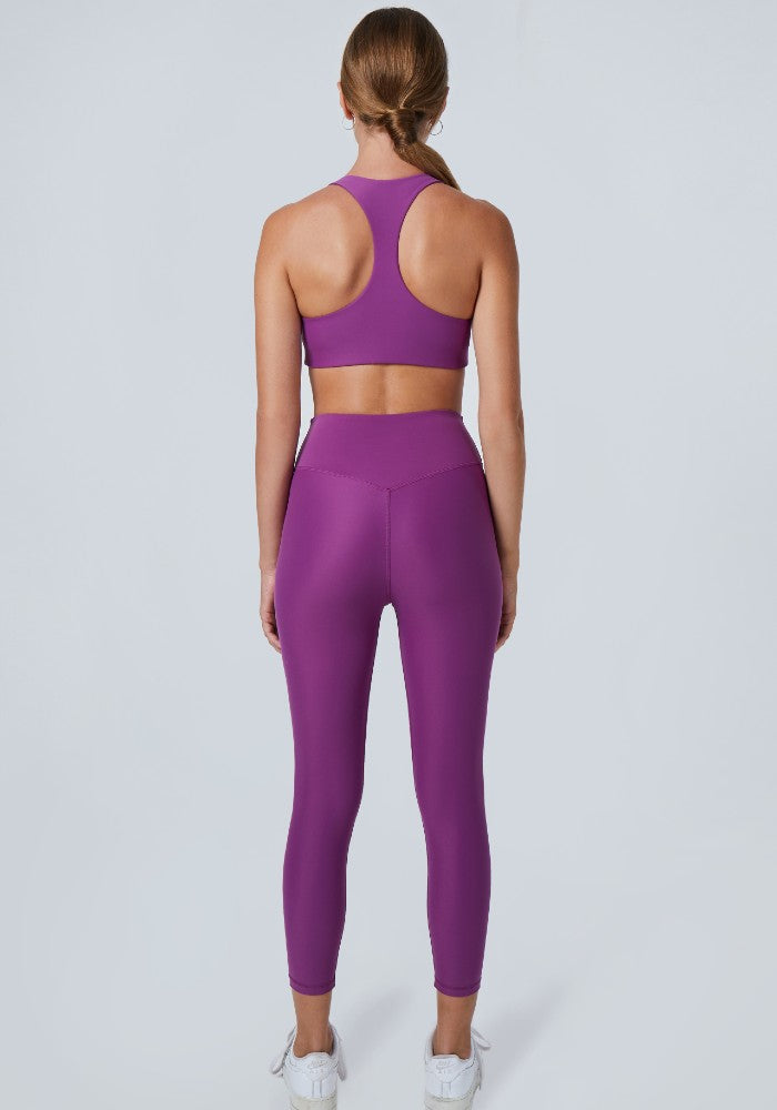 Back view of a woman wearing the Mila Leggings Plum by Outfyt color Purple made with ECONYL® regenerated nylon