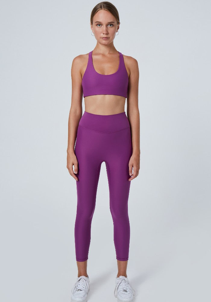 Front view of a woman wearing the Mila Leggings Plum by Outfyt color Purple made with ECONYL® regenerated nylon