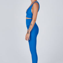 Load image into Gallery viewer, Side view of a woman wearing the Sage Leggings Aegean by Outfyt color Blue made with ECONYL® regenerated nylon
