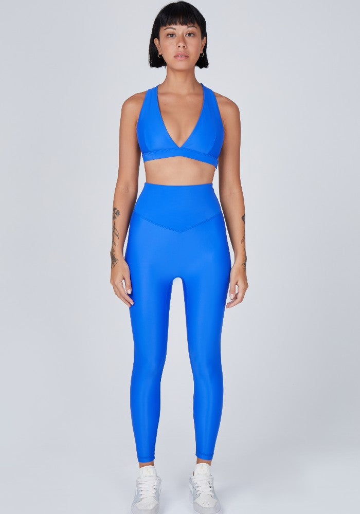 Front view of a woman wearing the Sage Leggings Lapis by Outfyt color Blue made with ECONYL® regenerated nylon