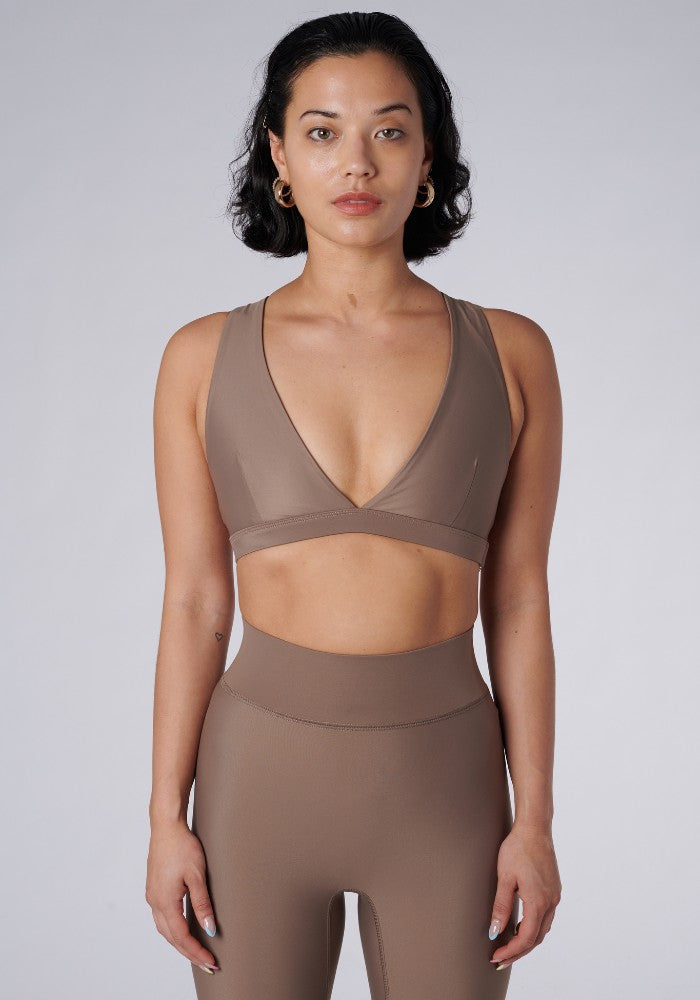 Front view of a woman wearing the Lilly V 2.0 Sand by Outfyt color Beige made with ECONYL® regenerated nylon