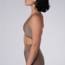Load image into Gallery viewer, Side view of a woman wearing the Lilly V 2.0 Sand by Outfyt color Beige made with ECONYL® regenerated nylon
