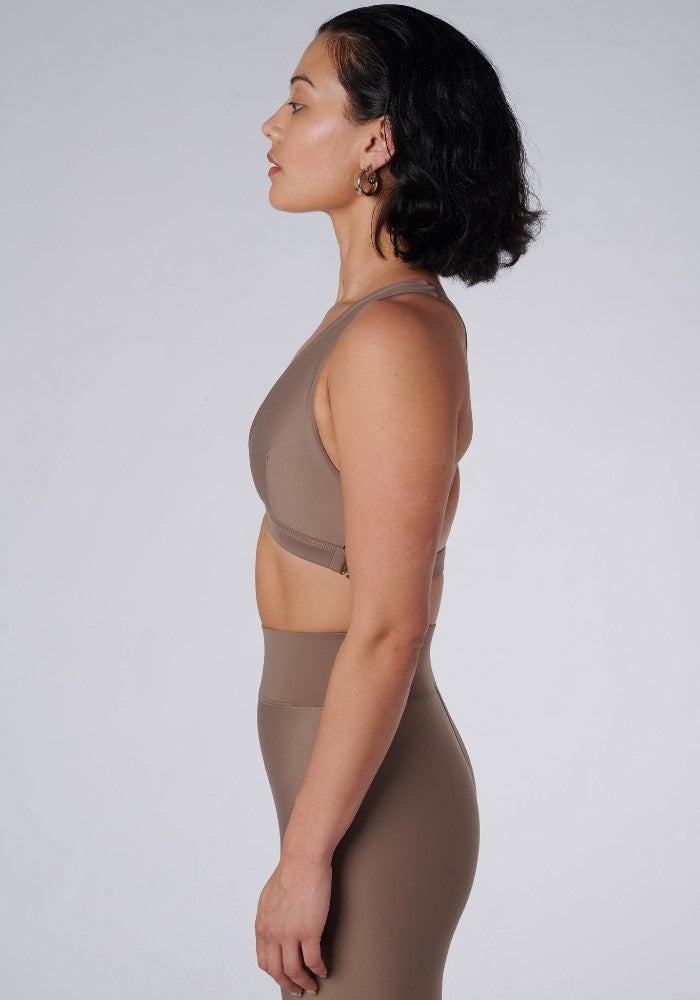 Side view of a woman wearing the Lilly V 2.0 Sand by Outfyt color Beige made with ECONYL® regenerated nylon