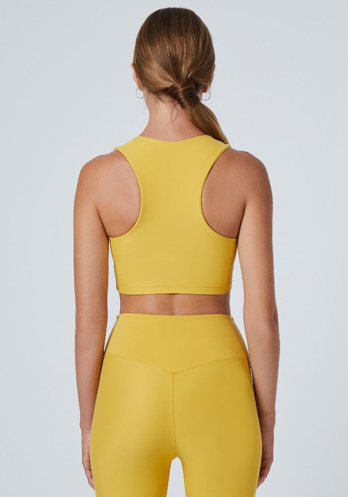 Back view of a woman wearing the Tula Crop Top Mustard by Outfyt color Yellow made with ECONYL® regenerated nylon