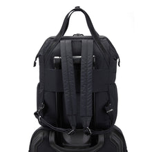 Load image into Gallery viewer, Back view of the Pacsafe Citysafe CX Anti-Theft Backpack color Black made with ECONYL® regenerated nylon on a luggage

