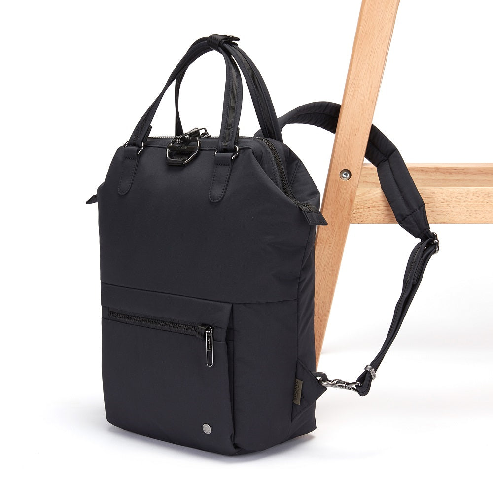 Side view of the Pacsafe Citysafe CX Anti-Theft Mini Backpack color Black made with ECONYL® regenerated nylon locked to a chair