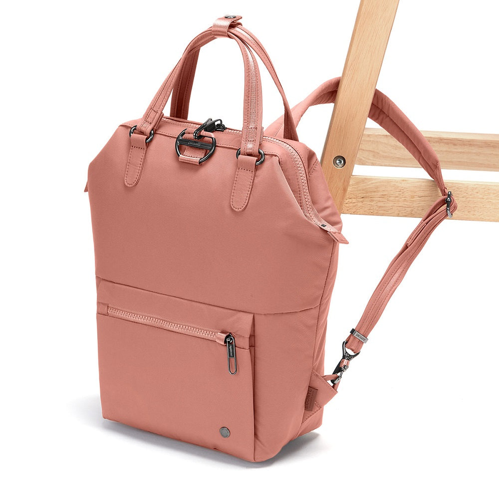 Side view of the Pacsafe Citysafe CX Anti-Theft Mini Backpack color Rose made with ECONYL® regenerated nylon locked to a chair