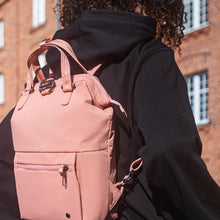 Load image into Gallery viewer, Woman travelling with the Pacsafe Citysafe CX Anti-Theft Mini Backpack color Rose made with ECONYL® regenerated nylon

