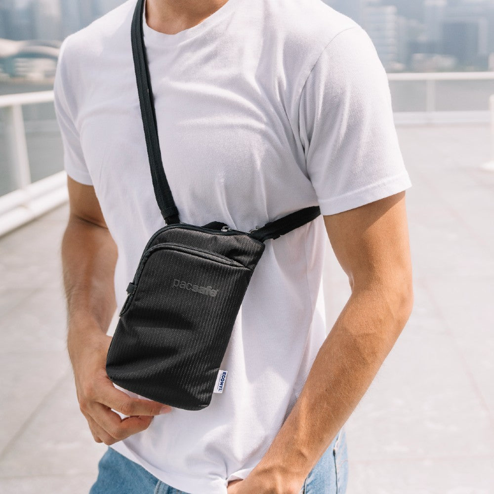 Man carrying the Pacsafe Daysafe Anti-Theft Tech Crossbody color Black made with ECONYL® regenerated nylon
