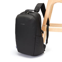 Load image into Gallery viewer, Side view of the Pacsafe Vibe 25L Anti-Theft Backpack color Black made with ECONYL® regenerated nylon locked to a chair
