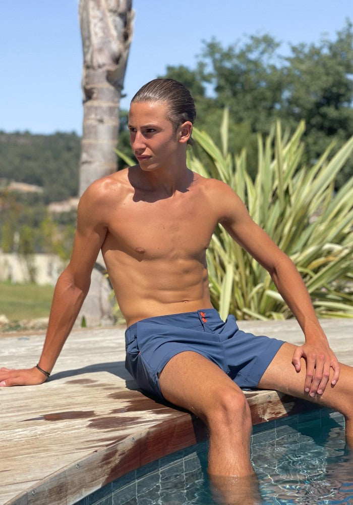 Man wearing the Milo Shorts Men's Swimsuit by Seawild color Blue made with ECONYL® regenerated nylon