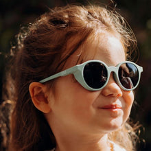 Load image into Gallery viewer, Young girl wearing SooNice Children Sunnies by SooNice color mint green made with ECONYL® regenerated nylon
